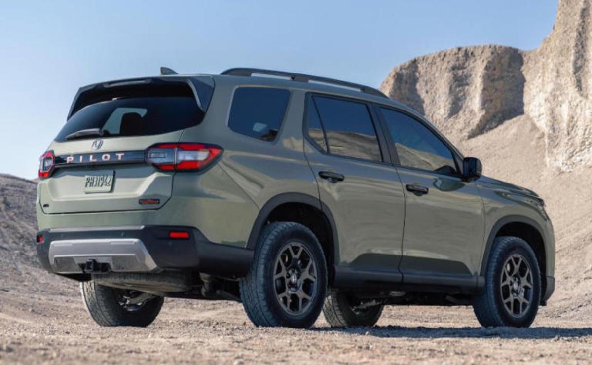 A rugged SUV parked on a rocky terrain with mountains in the background.