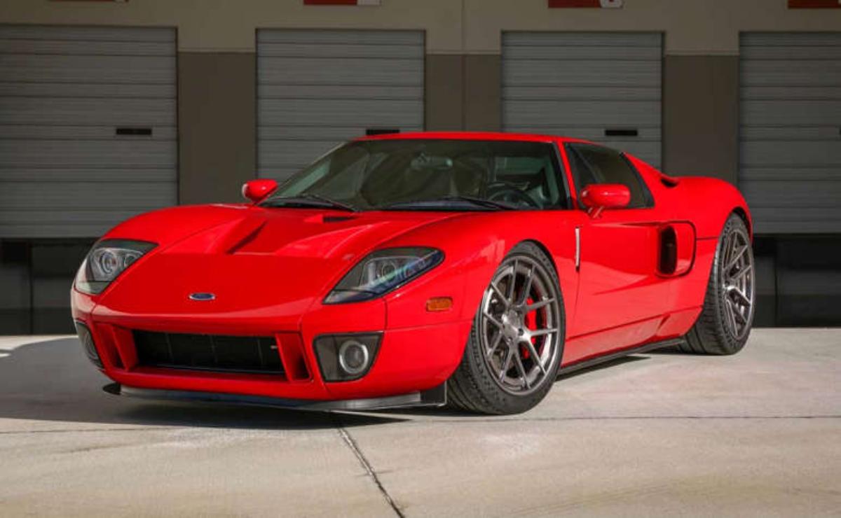 Red sports car parked in front of garage doors.