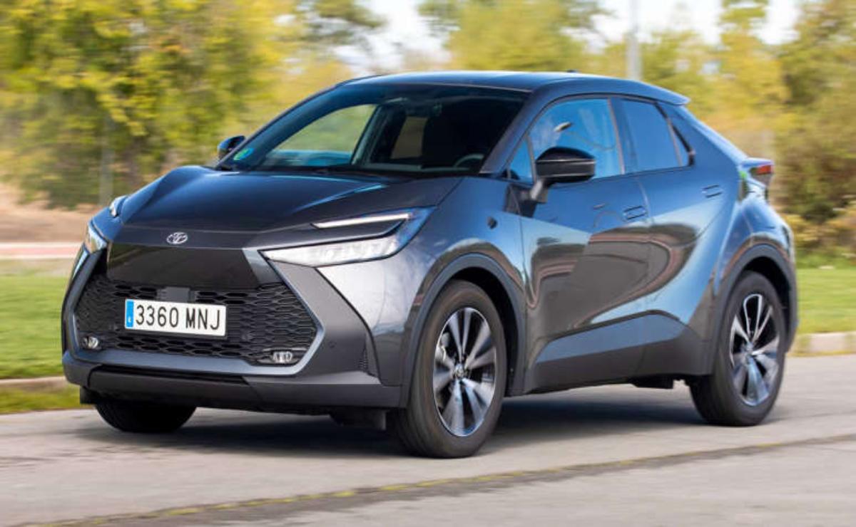 A sleek gray crossover SUV driving on a road with trees in the background.