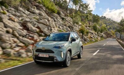 A silver SUV driving on a scenic mountain road.