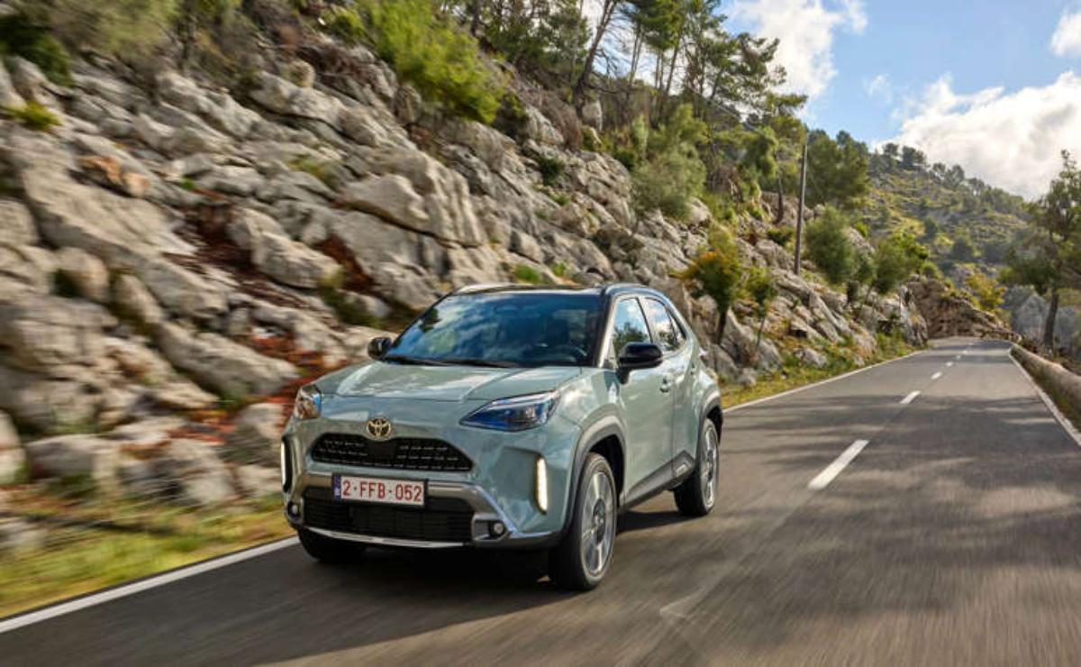 A silver SUV driving on a scenic mountain road.