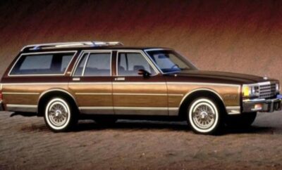 Classic brown station wagon with whitewall tires parked indoors.