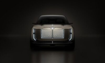Front view of a sleek luxury car with illuminated grille and sharp LED headlights.
