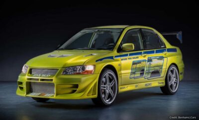 Yellow Mitsubishi Lancer Evolution with racing decals on display.