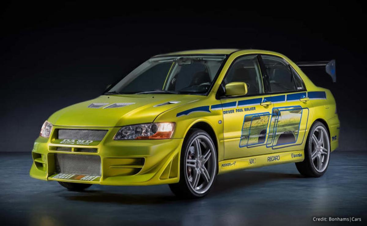 Yellow Mitsubishi Lancer Evolution with racing decals on display.