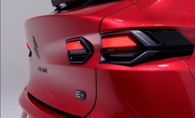 Close-up of a red car's rear taillight and emblem.