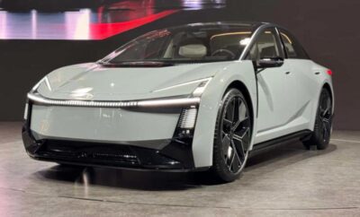Sleek white electric car with black accents showcased indoors.