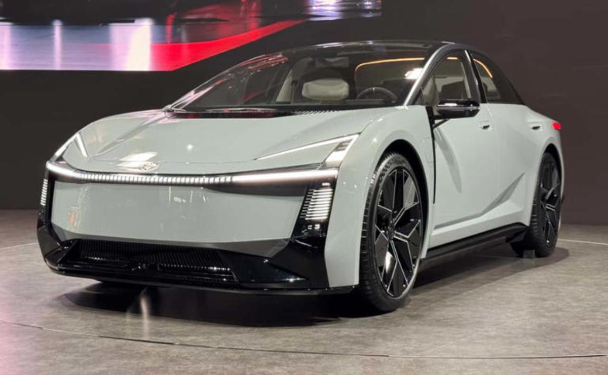 Sleek white electric car with black accents showcased indoors.