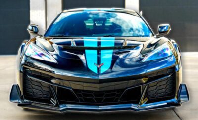 Black sports car with blue racing stripes on the hood.