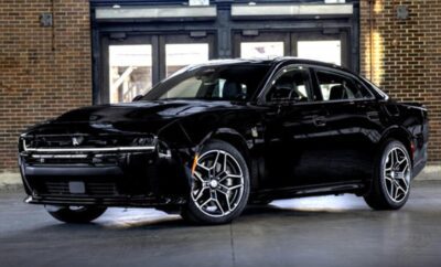 Black luxury sedan parked indoors with modern alloy wheels.