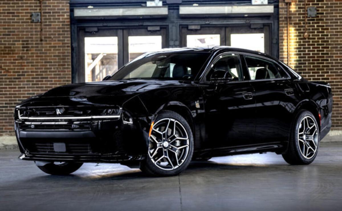Black luxury sedan parked indoors with modern alloy wheels.