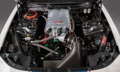 Close-up of a car engine with a prominent intake manifold and various components.