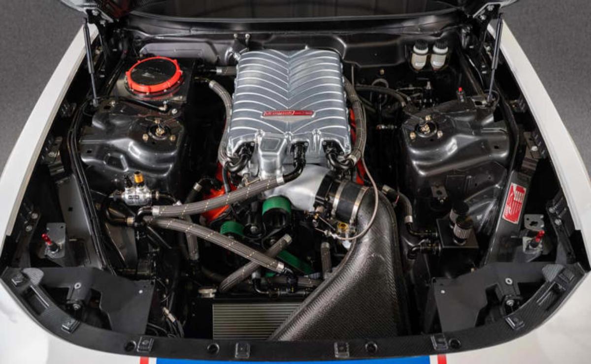 Close-up of a car engine with a prominent intake manifold and various components.