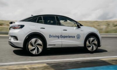 White Volkswagen electric car labeled 'Driving Experience' on a road.