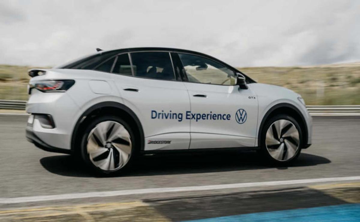 White Volkswagen electric car labeled 'Driving Experience' on a road.