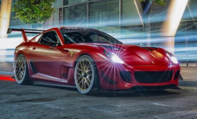 A sleek red sports car with glowing headlights on a city street at night.