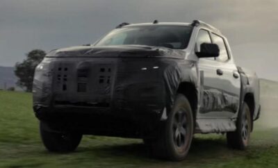A black SUV driving on a grassy field under a cloudy sky.