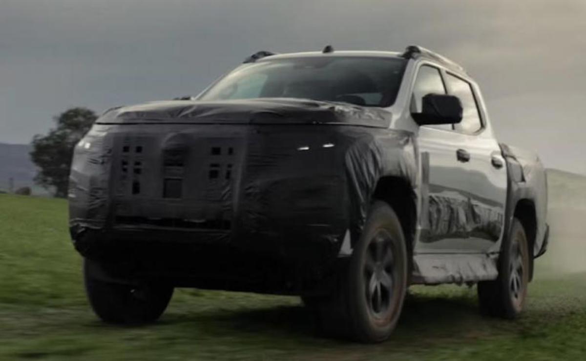 A black SUV driving on a grassy field under a cloudy sky.