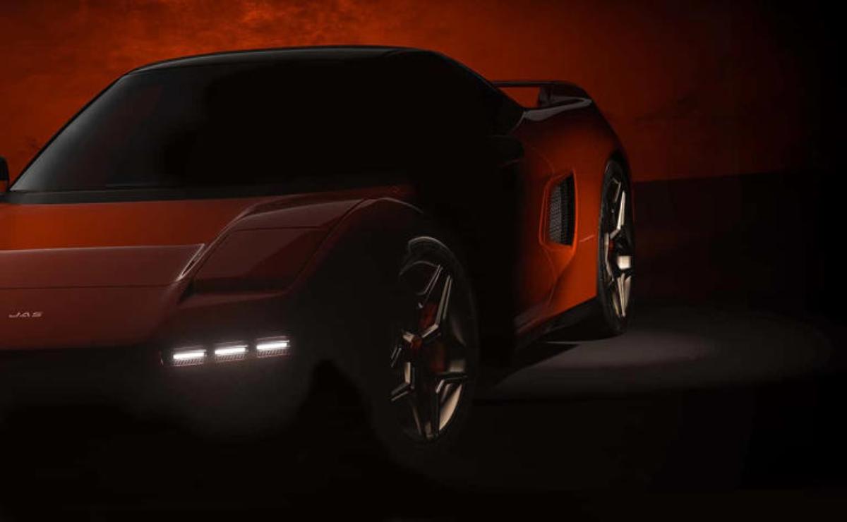 Sleek red sports car illuminated in low light, showcasing its modern design.