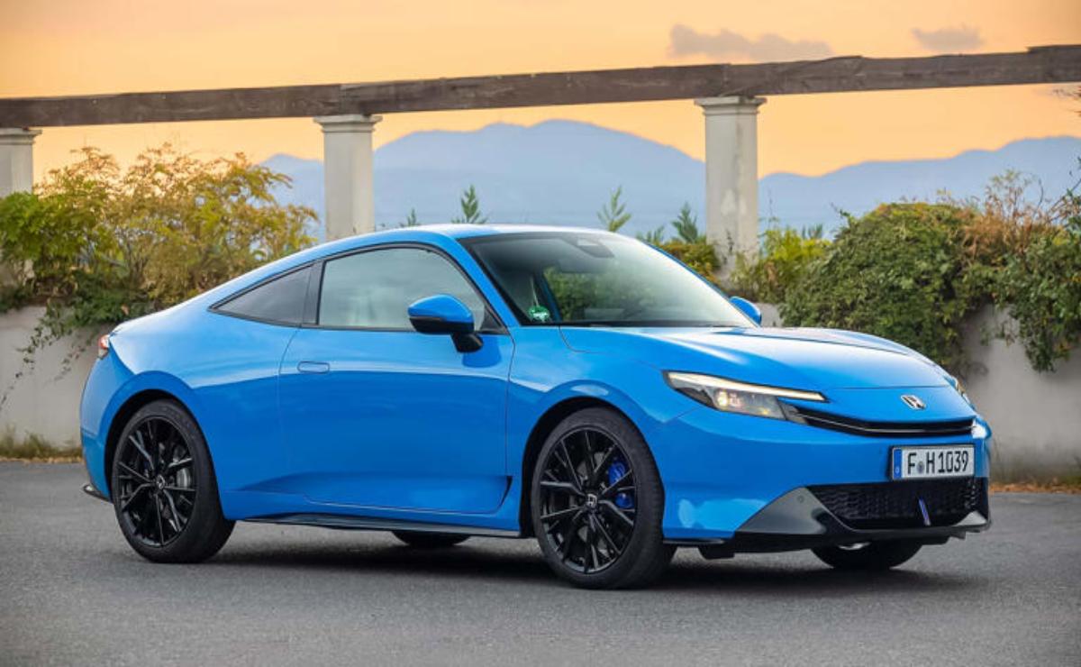 Sleek blue sports car parked with modern bridge backdrop.