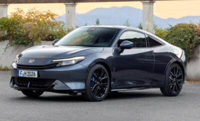 Sleek gray sports car parked with scenic mountain backdrop.