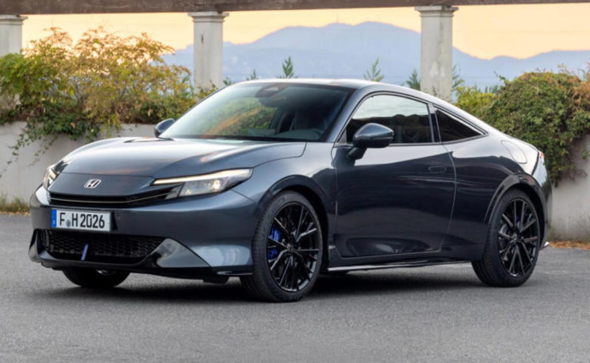 Sleek gray sports car parked with scenic mountain backdrop.