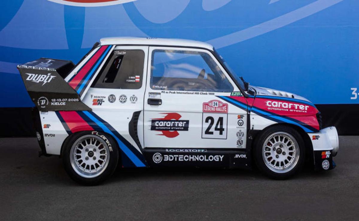 A vintage white racing car with blue and red stripes and number 24 on the door.