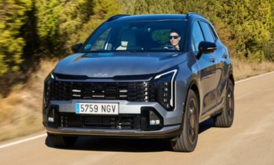 A black modern SUV driving on a rural road.