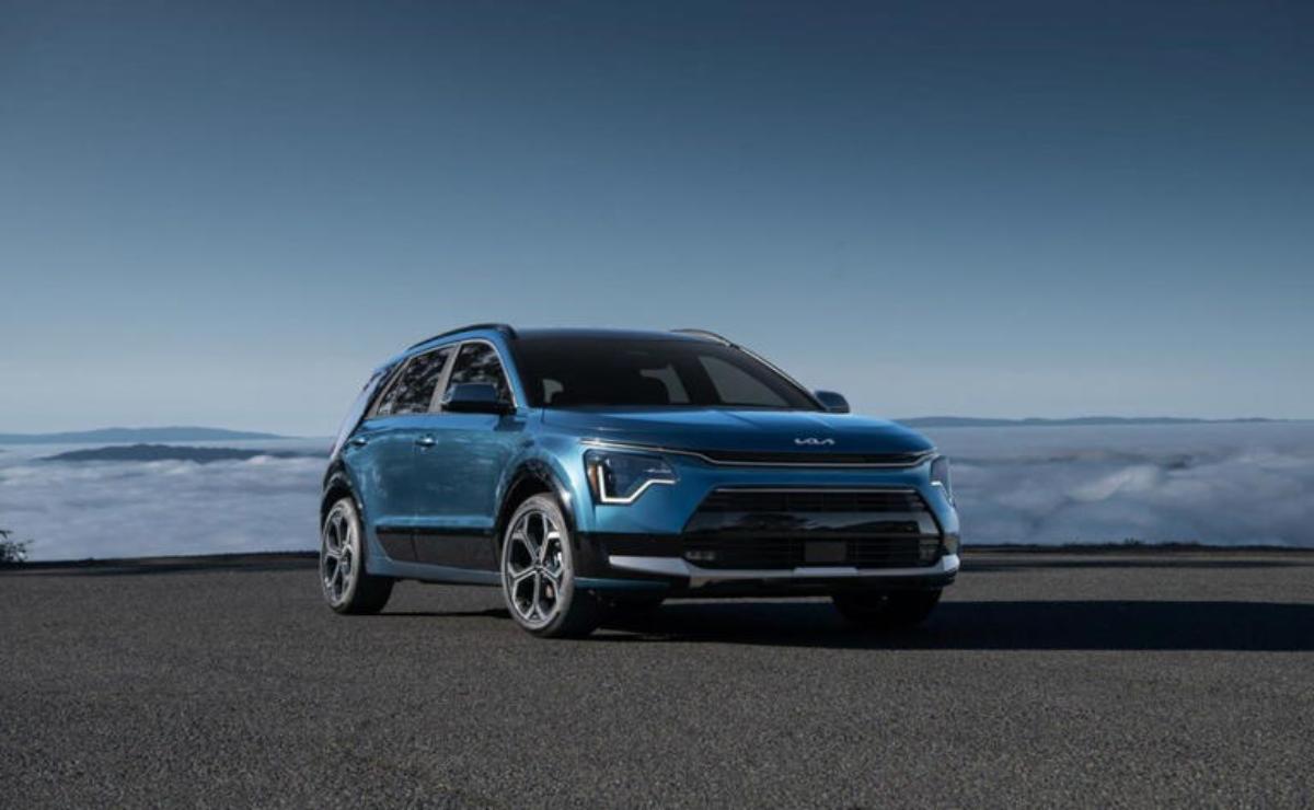 A sleek blue electric SUV parked on an open road under a clear sky.