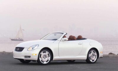 A white convertible car with a sleek design and brown interior.