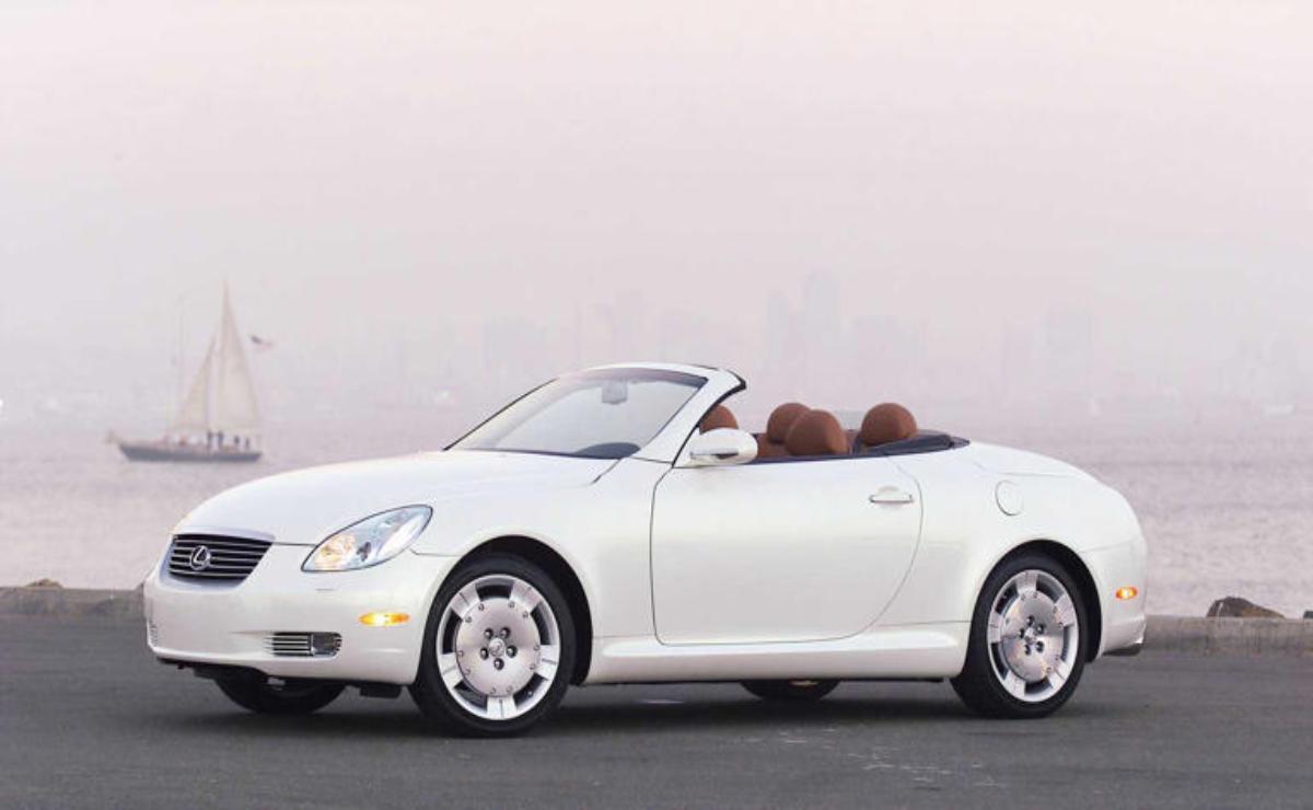 A white convertible car with a sleek design and brown interior.