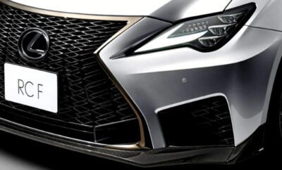 Close-up of a sleek silver car's front grille and headlight.