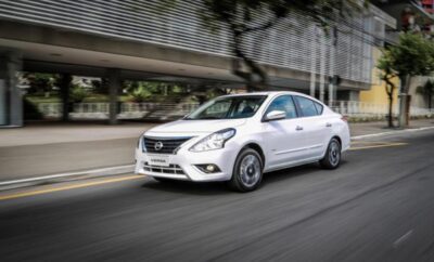 White sedan car driving on an urban road with motion blur.