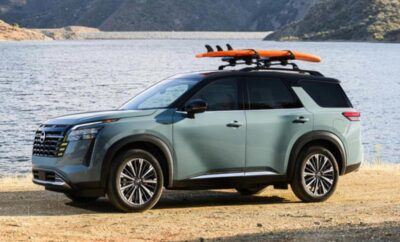 SUV parked by a lake with surfboards on the roof.