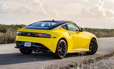 Yellow sports car parked on a rural road at sunset.