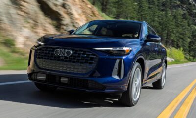 Blue Audi SUV driving on a mountain road.