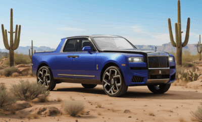 A blue luxury pickup truck parked on desert terrain.