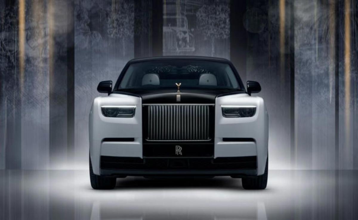 Front view of a luxurious Rolls-Royce car in a dimly lit setting.