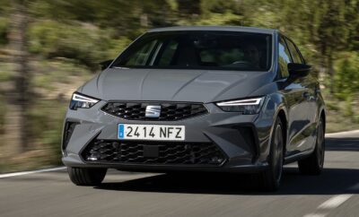 A sleek gray SEAT car driving on a road with a blurred natural background.