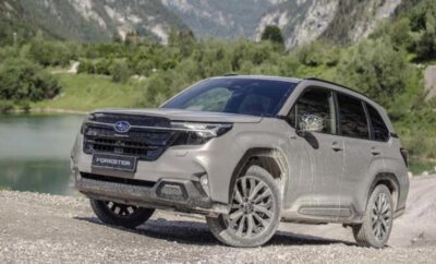 Silver Subaru Outback parked on a gravel road with mountains in the background.