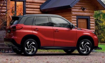 Red SUV parked in front of a wooden cabin with a blue awning.