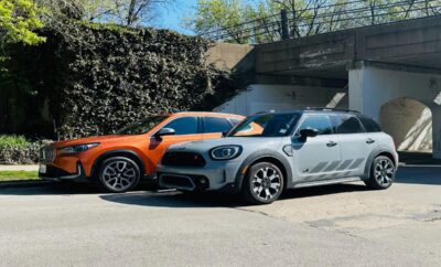 Two modern Mini Cooper cars parked side by side outdoors.