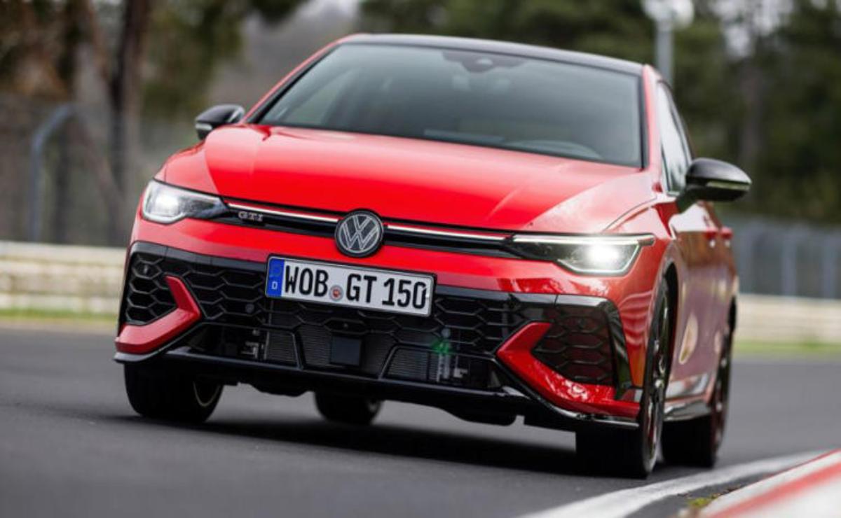 Red sports car speeding on the road with aggressive front design.