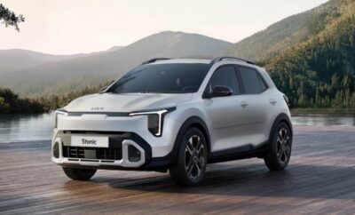 Sleek white electric SUV driving on a road with mountains in the background.