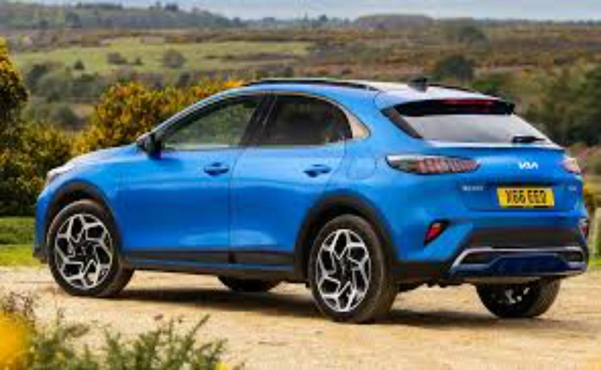 Blue compact SUV parked on a dirt path with countryside background.