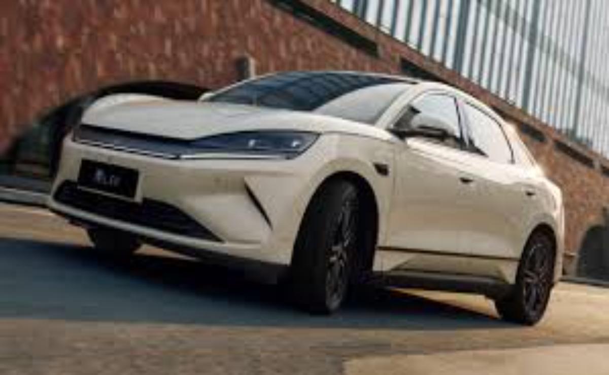 White electric SUV parked near a building with modern design.