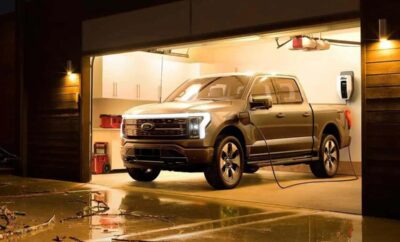 A silver pickup truck parked inside a dimly lit garage.