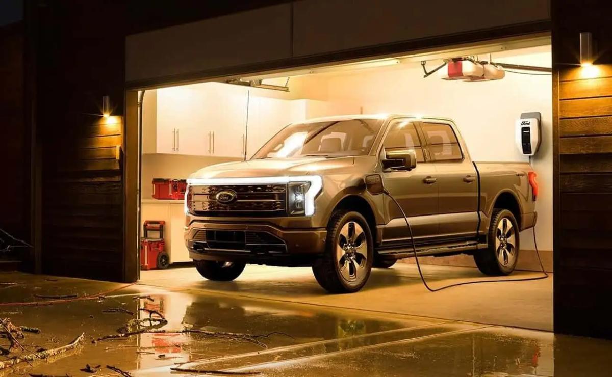 A silver pickup truck parked inside a dimly lit garage.