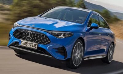 A blue Mercedes-Benz driving on a scenic road in daylight.