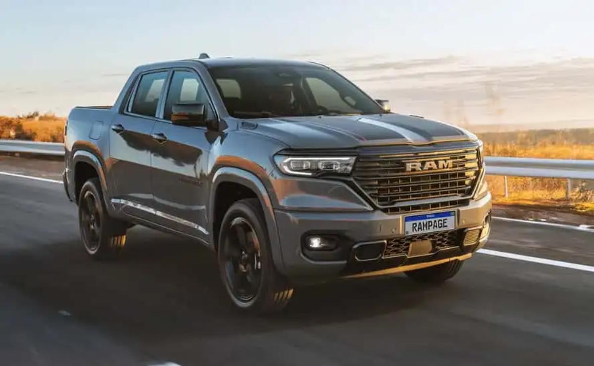 A sleek gray RAM pickup truck driving on a road during sunset.